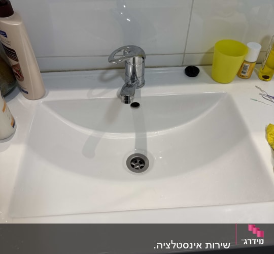 כיור עם ברז כרום ומוצרים על השיש
